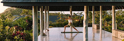 Guests in a yoga session on a floating pontoon at Kokomo Private Island Fiji