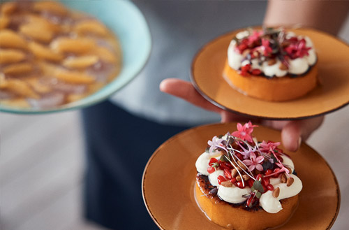 A Kokomo Island Fiji staff member serving an array of desserts.