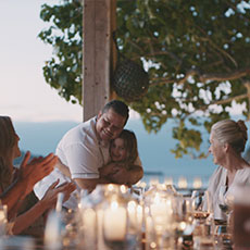 Chef Caroline interacting with guests during a large candlelit dinner.