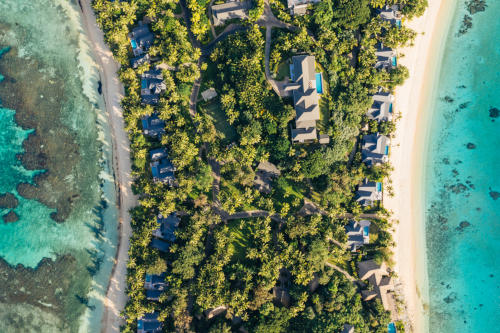 A bird’s-eye view of the middle section of the island showing some of the villas, a tennis court, and one of the residences at Kokomo Private Island.