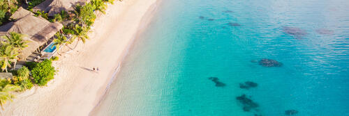 An aerial view of a beach at Kokomo Private Island Fiji and the nearby reefs
