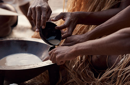 Close up of the locals pouring Kava into small drinking bowls at a ceremony.