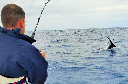 Guest reeling in large game fish off shore of Kokomo Private Island Fiji
