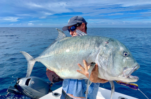 Jaga holding a large sports fish caught on a Kokomo Private Island Fiji fishing trip