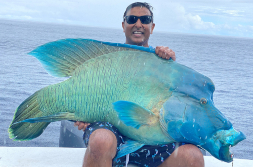 Jaga holding a large sports fish caught on a Kokomo Private Island Fiji fishing trip