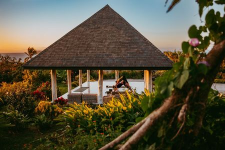 Guests practicing yoga in a hut surrounded by greenery at Kokomo Island Fiji.