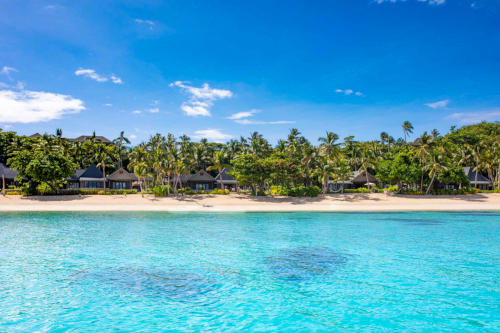 Beachfront villas nestled amongst lush vegetation at Kokomo Private Island Fiji.