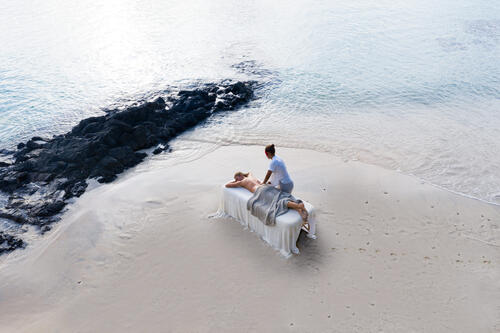 A guest receiving a massage on the beach at Kokomo Private Island Fiji.