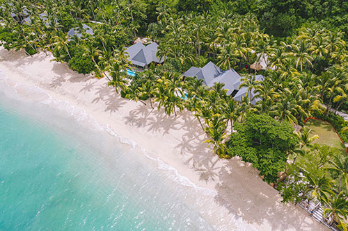 Beachfront villas at Kokomo Private Island Fiji viewed from the water.