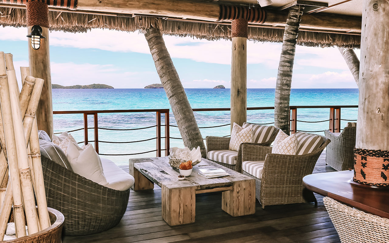 Beach bar with seating overlooking the ocean at Kokomo Private Island Fiji