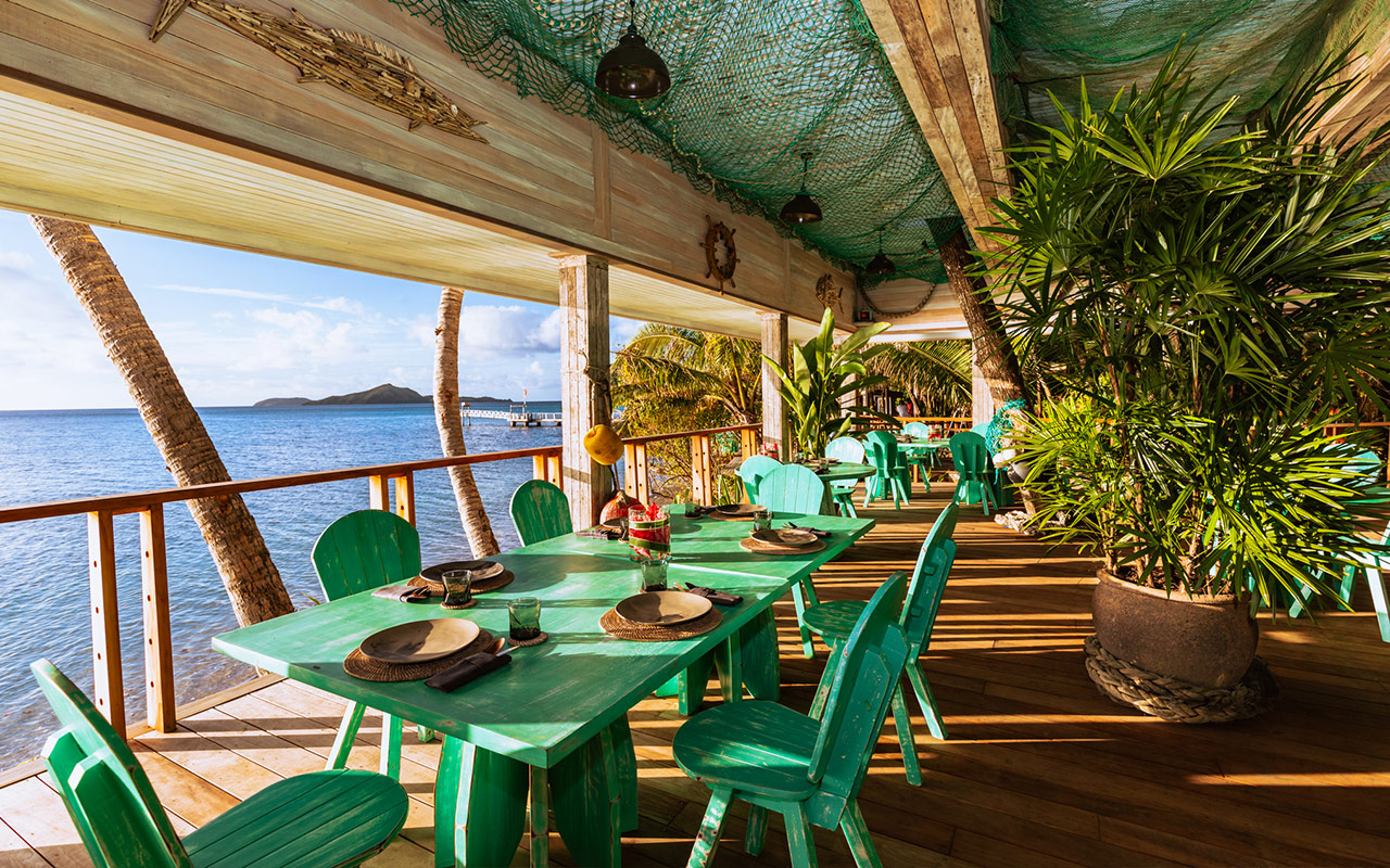 Walker D'Plank with dining tables set up overlooking the ocean at Kokomo Private Island Fiji