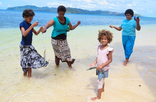 Fijian people fishing in the shallow water at Kokomo Private Island Fiji