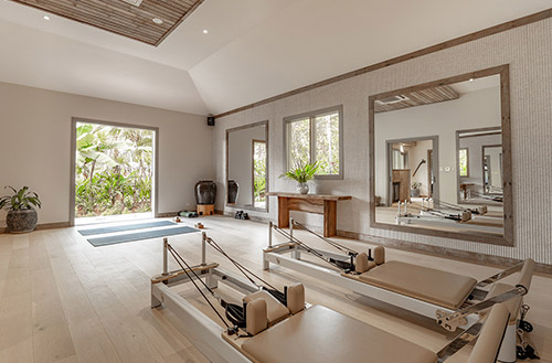 A guest working out inside a tastefully appointed gym at Kokomo Island Fiji.