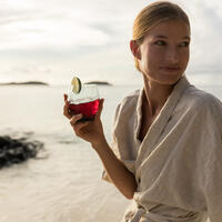 A guest enjoying a fresh health drink on the beach at Kokomo Private Island Fiji