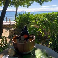 A bucket holding bottles of health drink on a beachside table at Kokomo Private Island Fiji